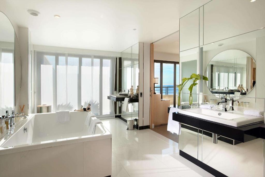 尼斯凯悦尼斯地中海宫殿酒店的带浴缸、两个盥洗盆和镜子的浴室