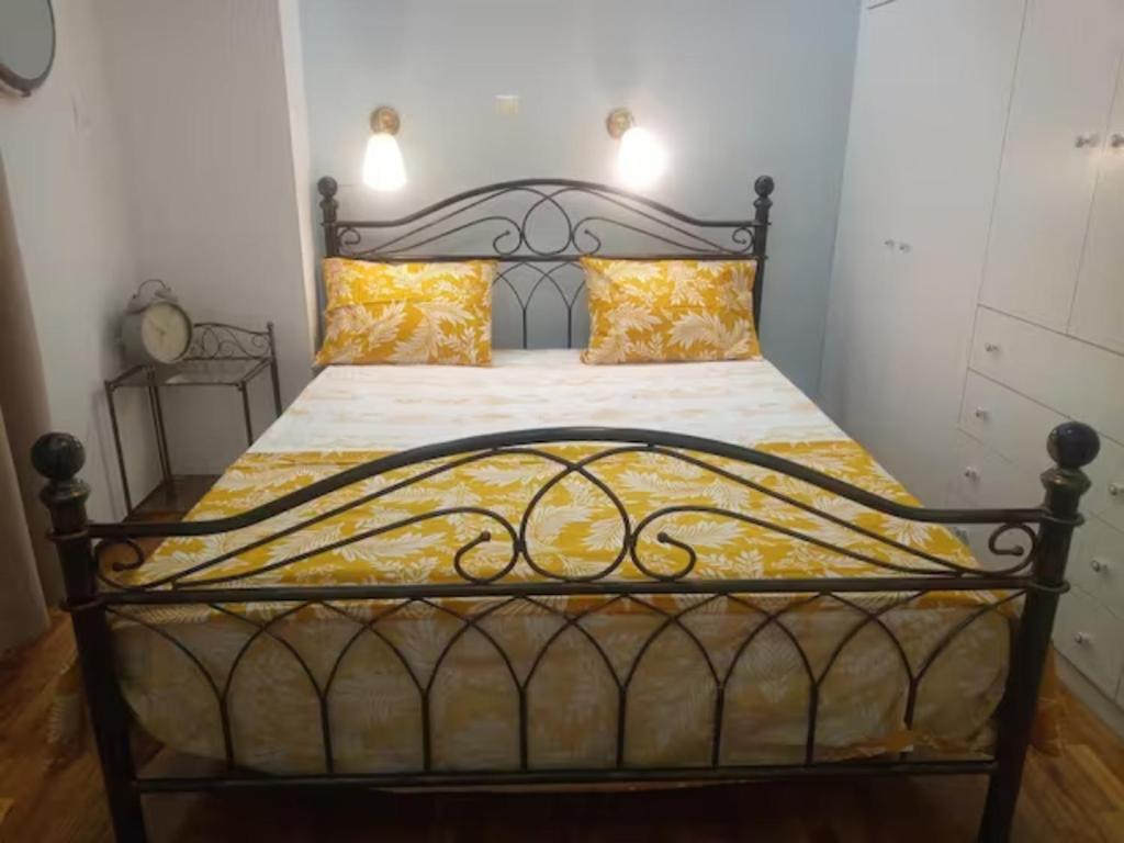 比雷埃夫斯Freatida apartment的一间卧室配有黑色床和黄色枕头