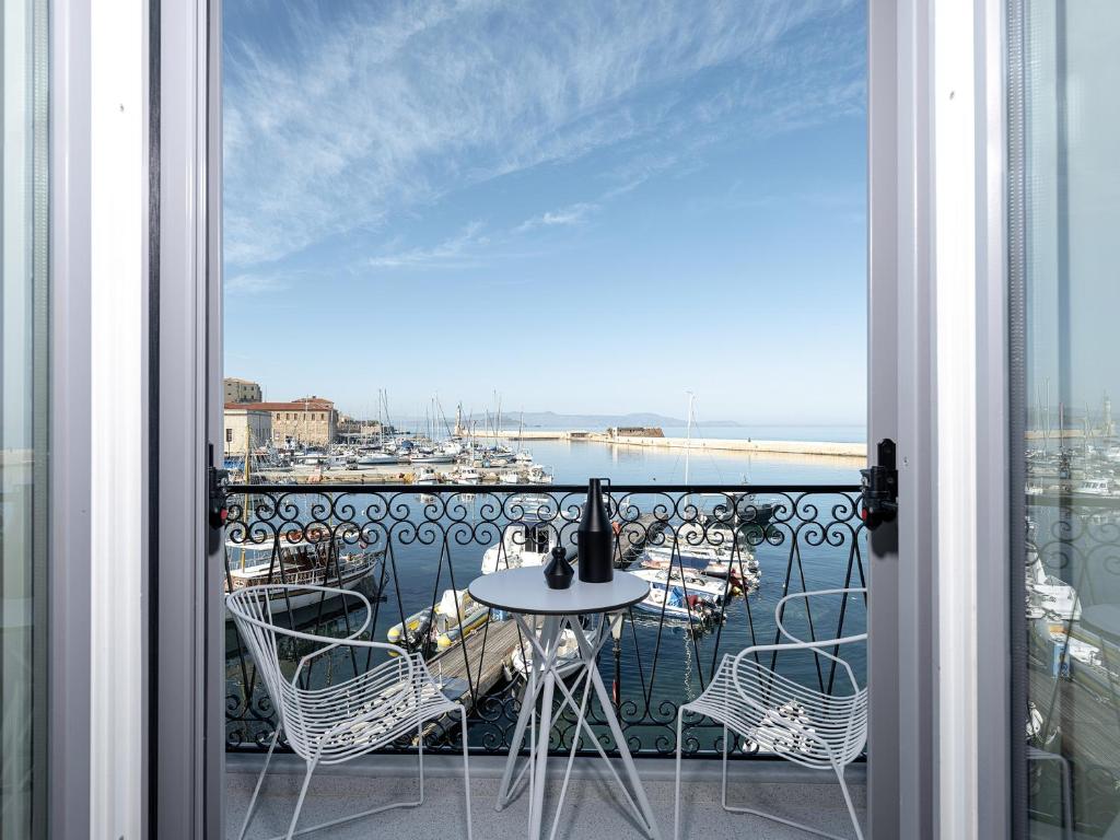 干尼亚Riviera Suites的阳台配有桌椅,享有海港的景致。
