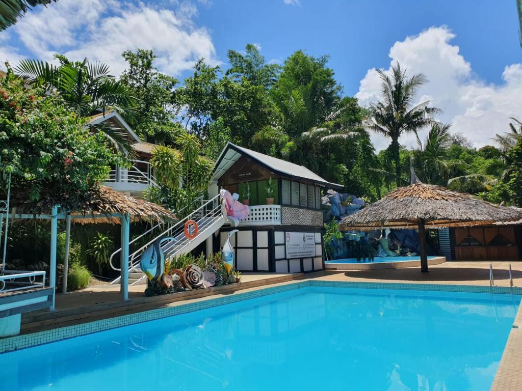 霍尼亚拉Honiara Hotel的一个带游泳池和房子的度假胜地