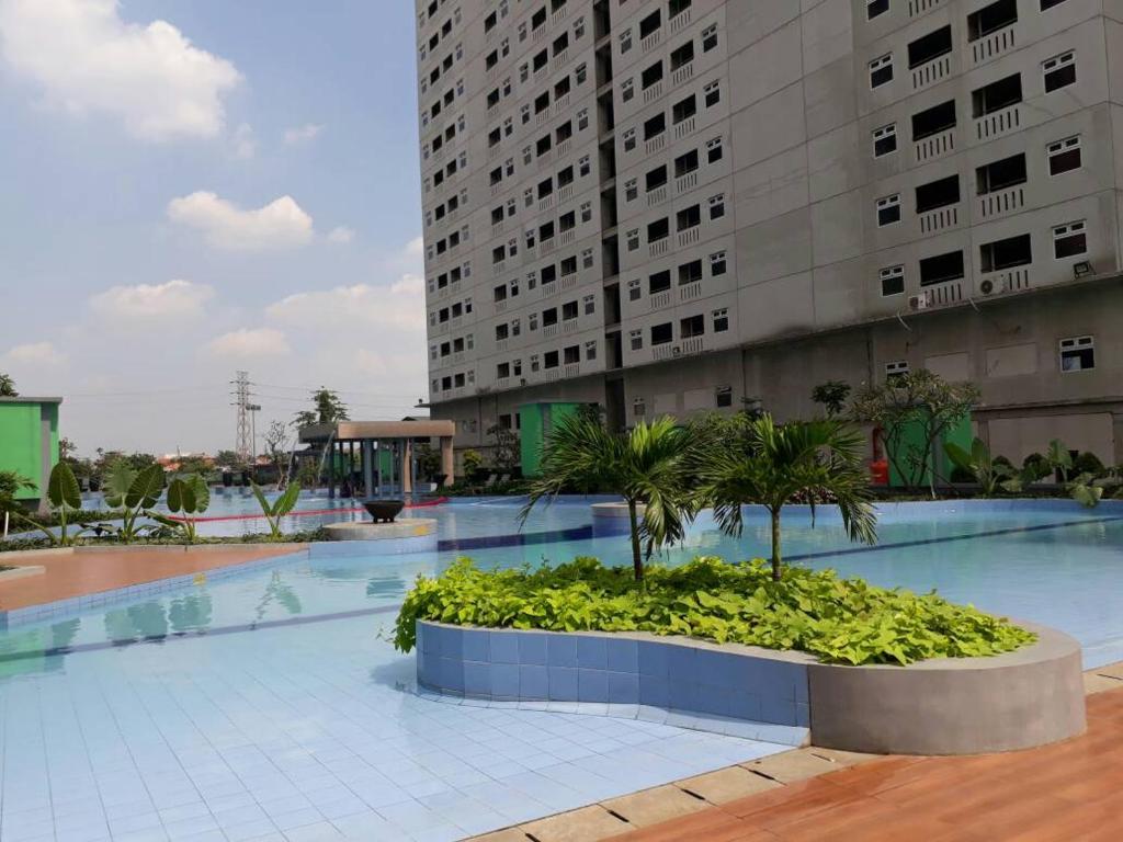 雅加达Green Pramuka City的大型游泳池,设有大型建筑