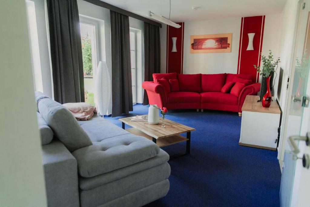 阔克威兹Ferienhaus LORINI的带沙发和红色沙发的客厅