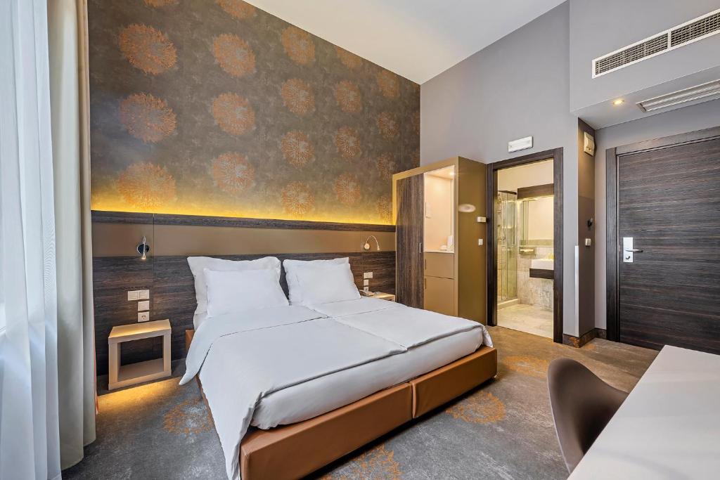 布达佩斯布达佩斯博物馆酒店的卧室配有一张床,墙上挂有绘画作品