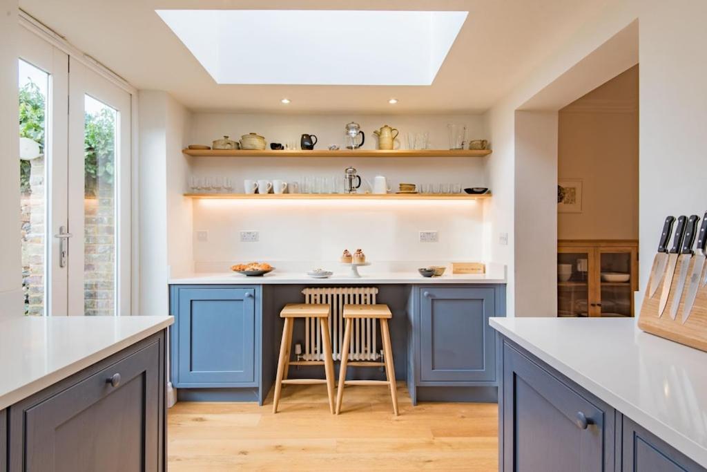 布罗德斯泰Liberty Cottage的厨房配有蓝色橱柜和天窗。
