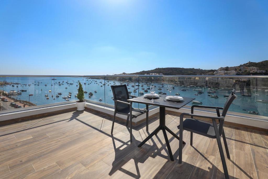 圣保罗湾城Seaview Stays的阳台享有海港景致,配有桌椅。