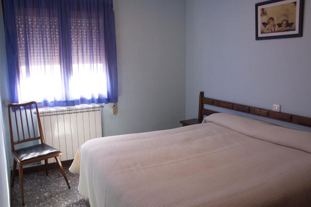 瓜尔迪奥拉-德贝尔加杜奈酒店的卧室配有床、椅子和窗户。