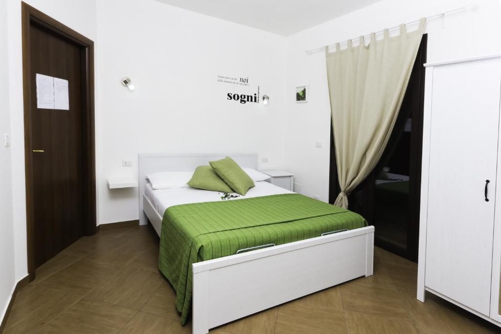 Villaggio RestaDolce Salento的一间卧室配有一张带绿毯的床