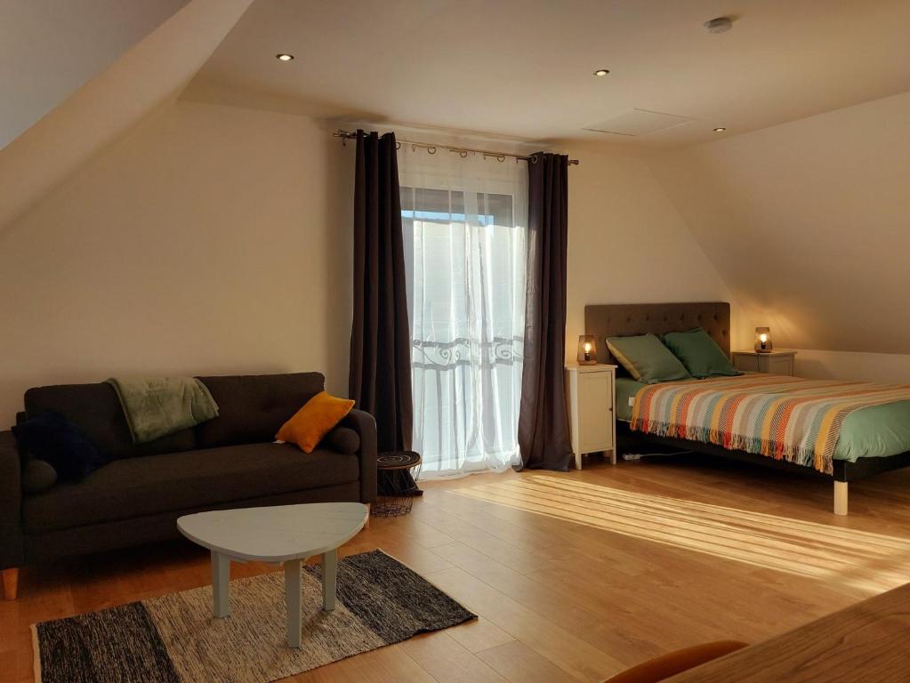 CuvergnonLa Chambre du Valois的客厅配有沙发和1张床