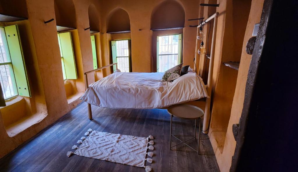 阿尔哈姆拉Bait Al Aali Guesthouse的一间设有床铺的卧室,位于带窗户的房间内