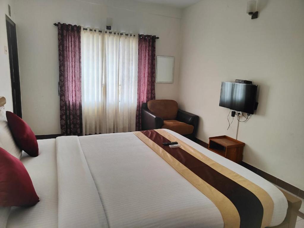 钦奈Kapsstone HOMESTAY- Apartments &Rooms near APOLLO &SHANKARA NETHRALAYA HOSPITALS -Greams Road的一间卧室配有一张床、一把椅子和电视