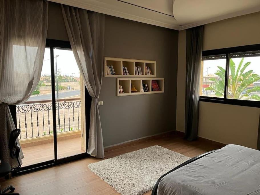 马拉喀什Marrakech le joyau Big villa piscine privée jardin的一间卧室设有一张床和一个阳台