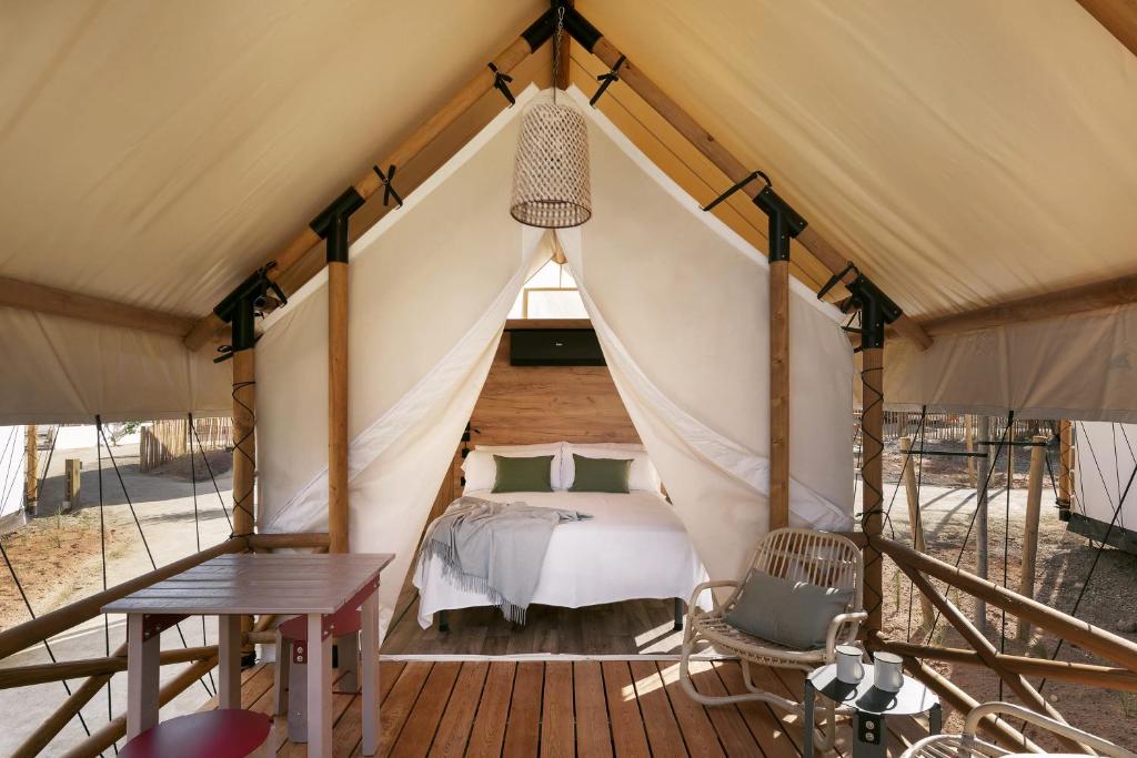 卡达克斯wecamp Cadaqués的帐篷内的卧室,配有一张床和一张桌子