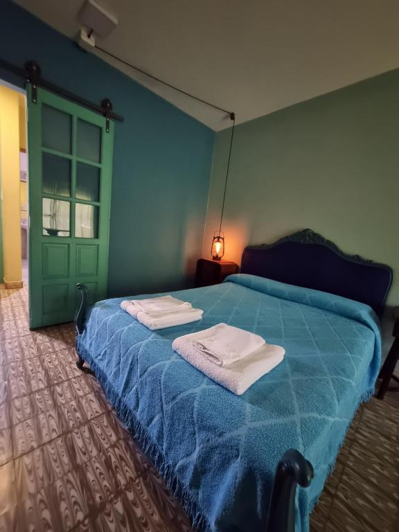 赫苏斯玛丽亚Acogedora suite con ingreso independiente.的一间卧室配有蓝色的床和毛巾