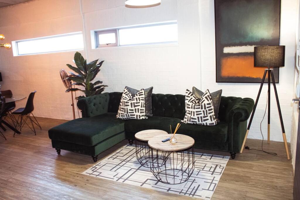 开普敦Swift Studios No4的客厅配有绿色沙发和桌子