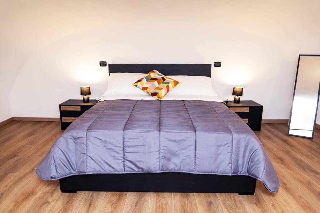 那不勒斯Artisti Home Naples的一间卧室配有一张带2晚台的大型紫色床