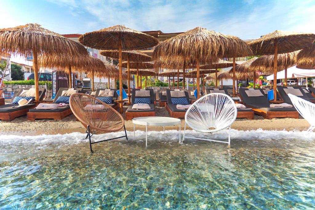 波利克罗诺Hotel Odysseas的海滩上的一组椅子和遮阳伞