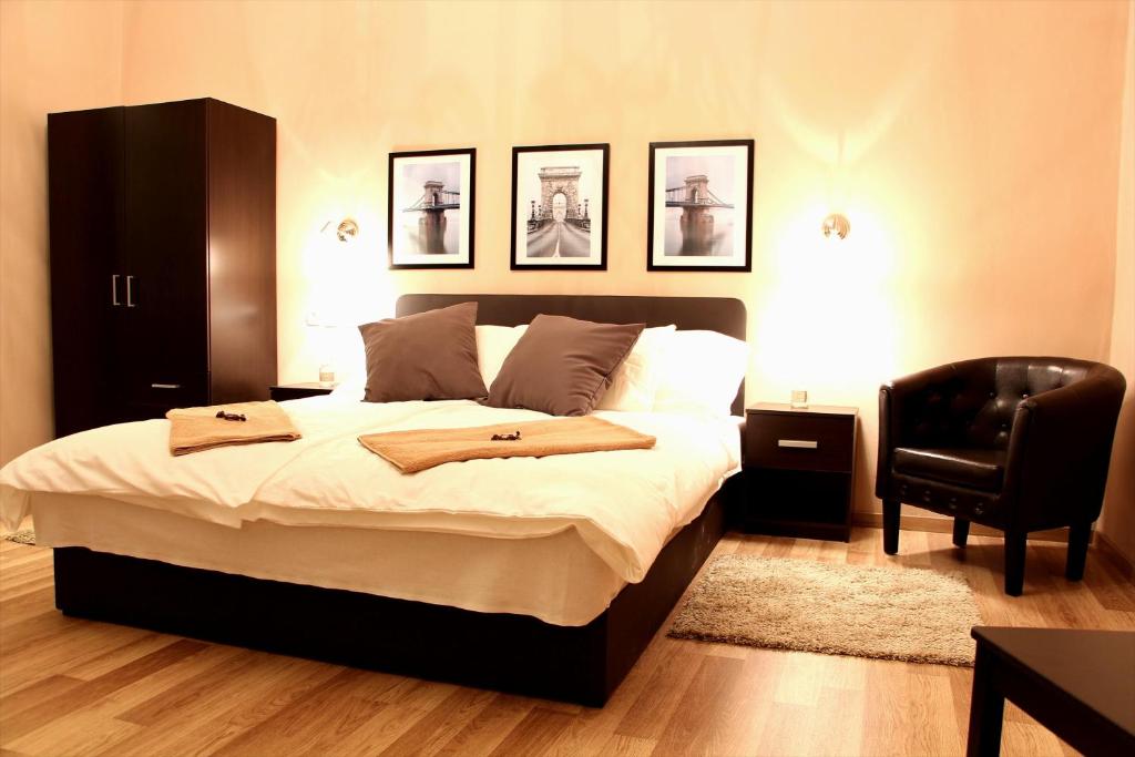 布达佩斯布达佩斯威乐住宿加早餐旅馆的一间卧室配有一张大床和一张黑椅