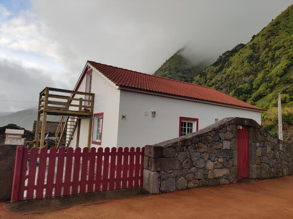 CalhetaCasa da Eira的白色的房子,有红色的栅栏和山