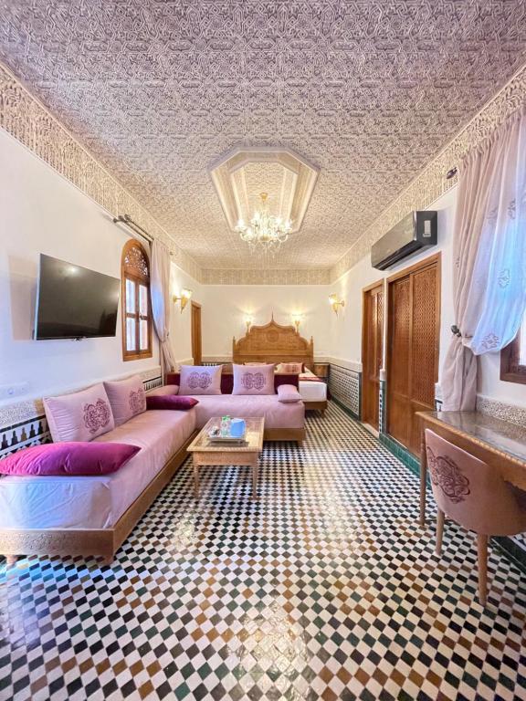非斯Le Grand Alcazar - Riad的客厅配有沙发和桌子