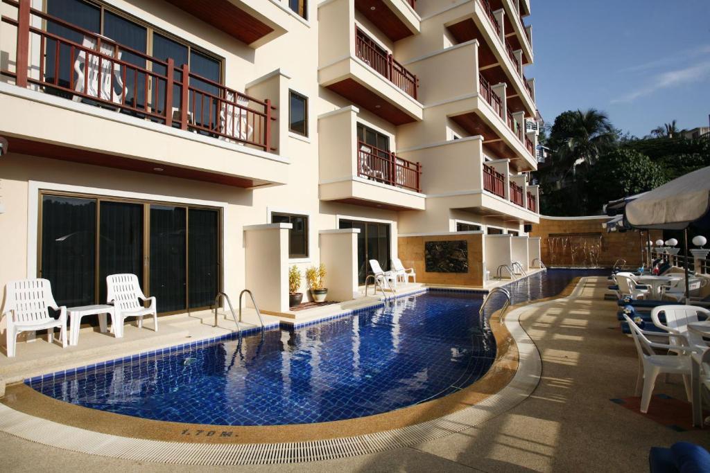 芭东海滩Jiraporn Hill Resort的大楼前的酒店游泳池