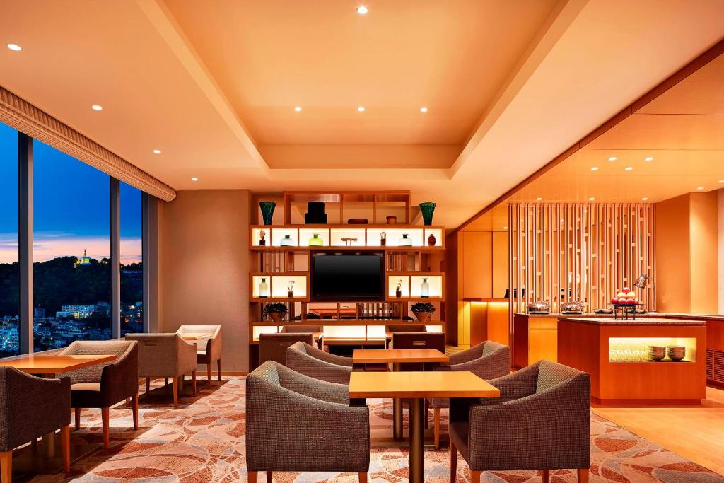 广岛广岛喜来登大酒店的酒店客房配有桌椅和电视。