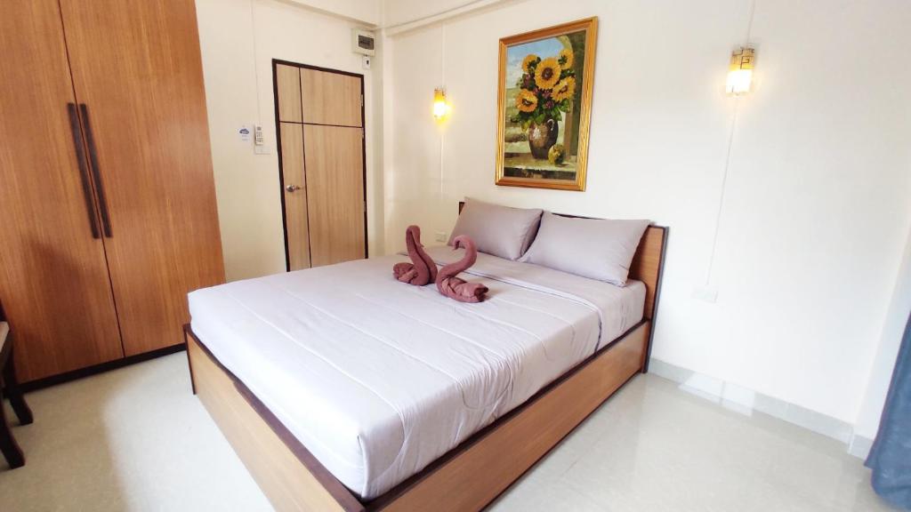 Ban Khlong Nong Yai66 Apartment的床上躺着一只粉红色的动物
