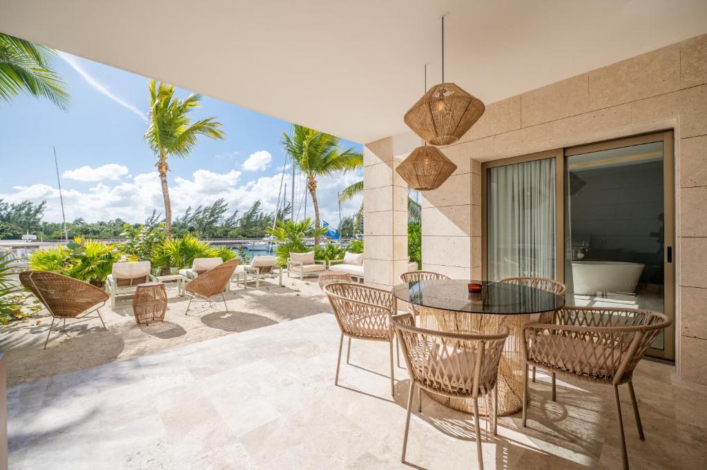 坎昆La Amada Cancun的一个带桌椅和棕榈树的庭院