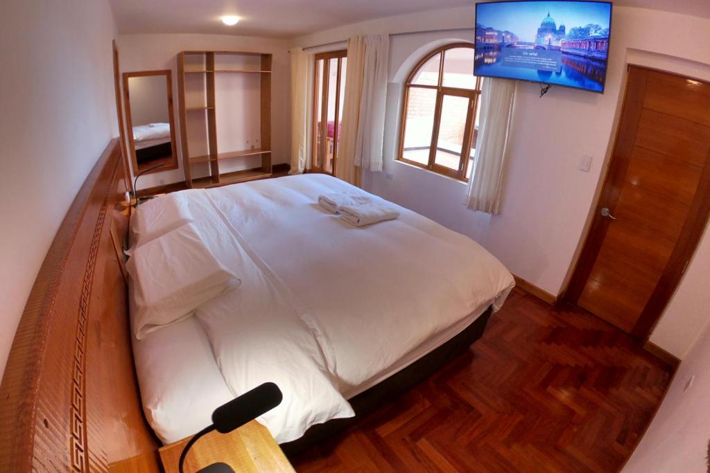 瓦拉斯Akilpo Home的卧室配有一张大床,墙上配有电视