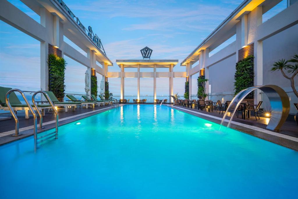 岘港钻石海酒店的一座配有桌椅的酒店游泳池