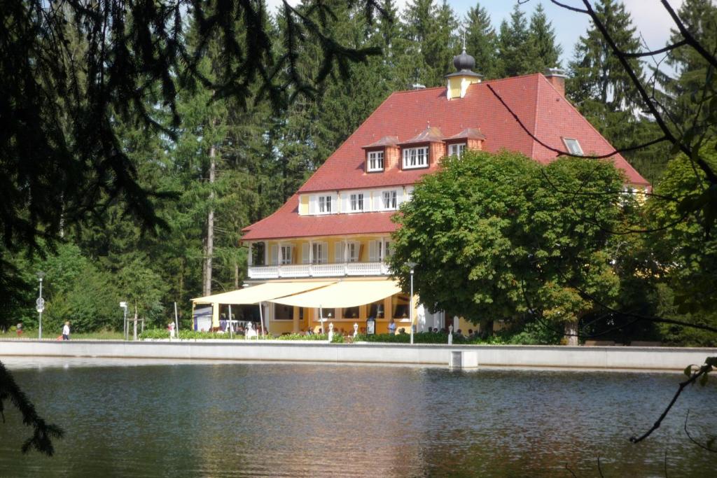 林登贝格瓦尔德西酒店的湖畔红色屋顶的大房子
