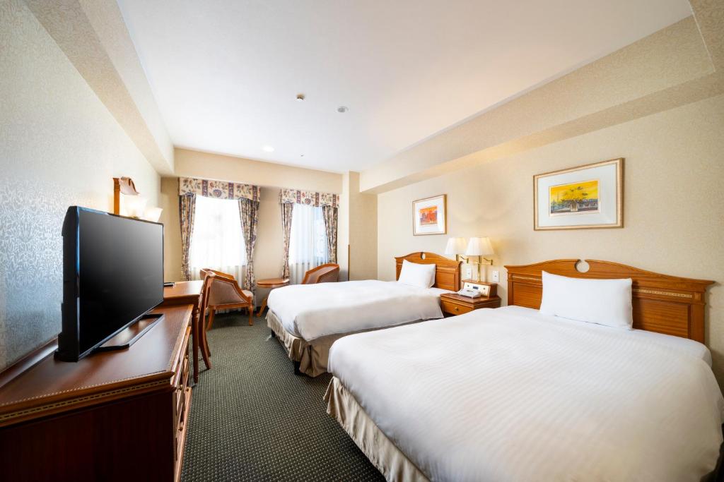 名古屋KOKO HOTEL Nagoya Sakae的酒店客房设有两张床和一台平面电视。