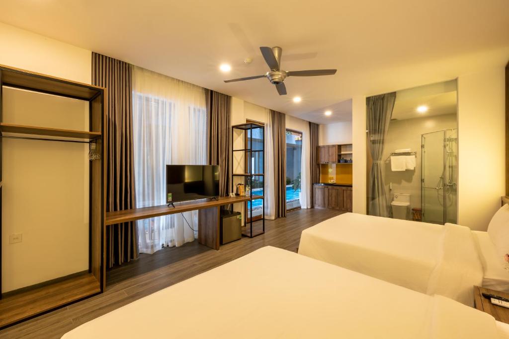 顺化Moon Sun Boutique Villa Hotel的酒店客房设有两张床和电视。