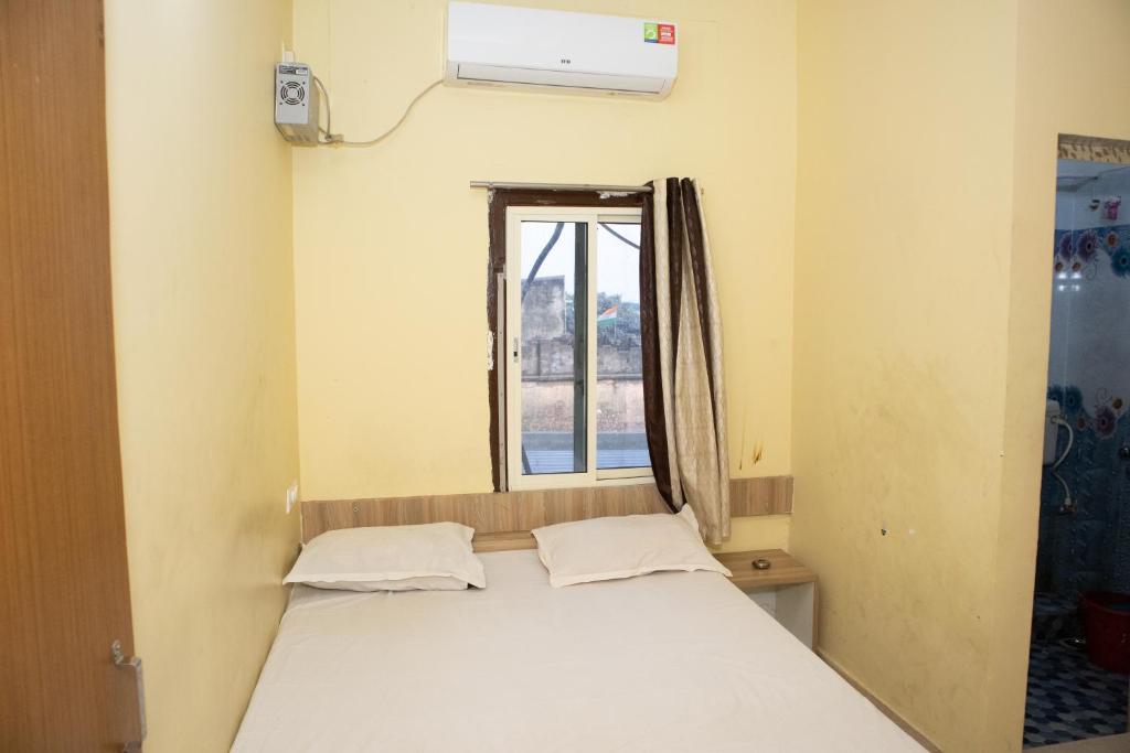 克塔克Ganesh Residency的窗户客房内的一张床位