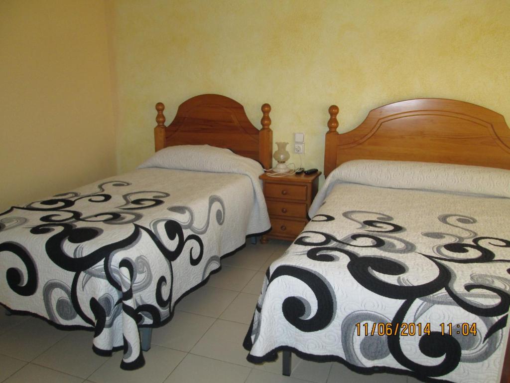 Saus佩西奥阿维佩普酒店的一间卧室配有两张床和一个带裙子的床头柜。