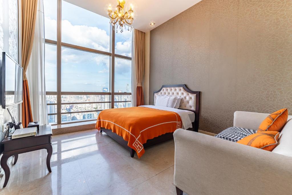 广州广州正佳金殿维福顿公寓（广交会期间免费穿梭巴士）的一间卧室配有一张床、一张沙发和一个大窗户