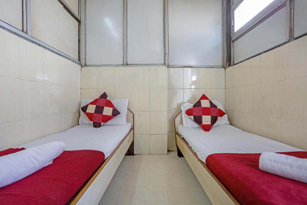 孟买Terminus Hotel Bandra的小客房内的两张床,配有红色和白色枕头