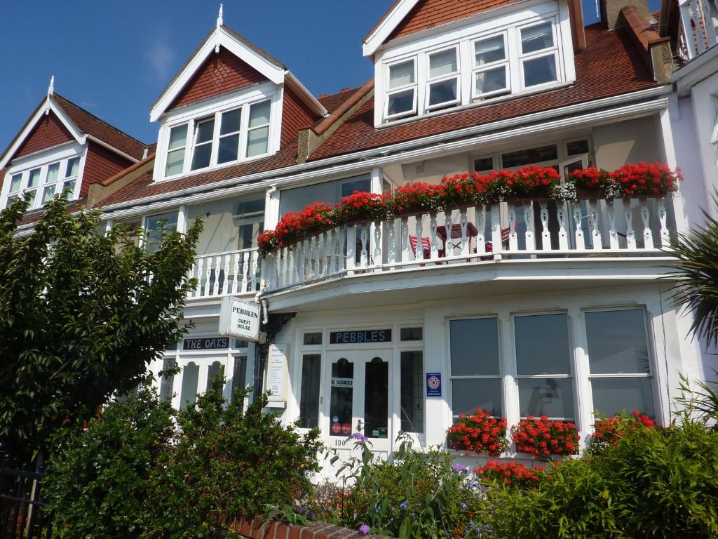 滨海绍森德鹅卵石旅馆的白色的房子,设有红色鲜花阳台
