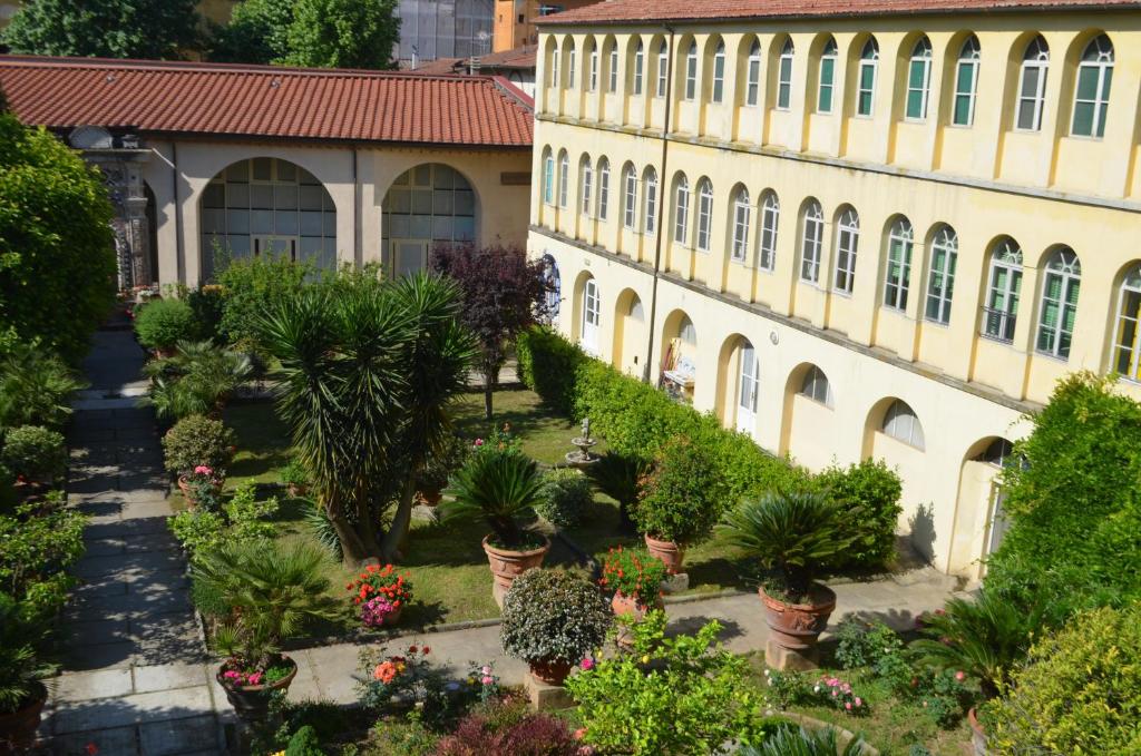 比萨Casa per ferie religiosa Figlie di Nazareth的一座种植盆栽植物的建筑的庭院