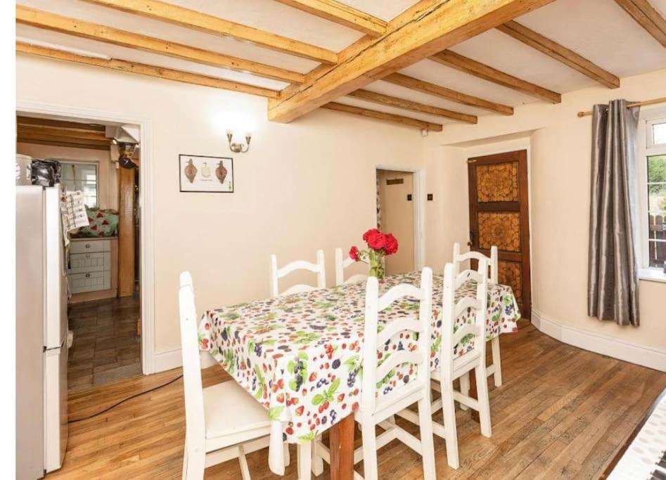 诺廷利Cosy Cottage的厨房以及带桌椅的用餐室。