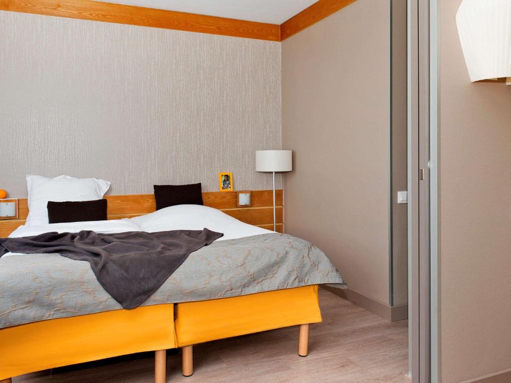 巴黎巴黎XV阿德吉奥公寓酒店的一间卧室配有一张大床和木制床头板
