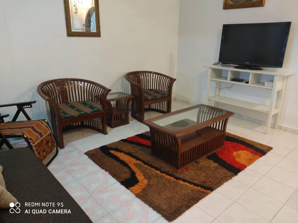 Simpang RenggamR&R HOMESTAY的客厅配有四把椅子和电视