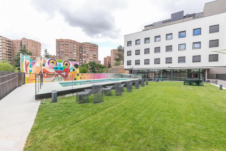 马德里micampus Madrid Sinesio Delgado Student Residence的一座壁画建筑前的公园