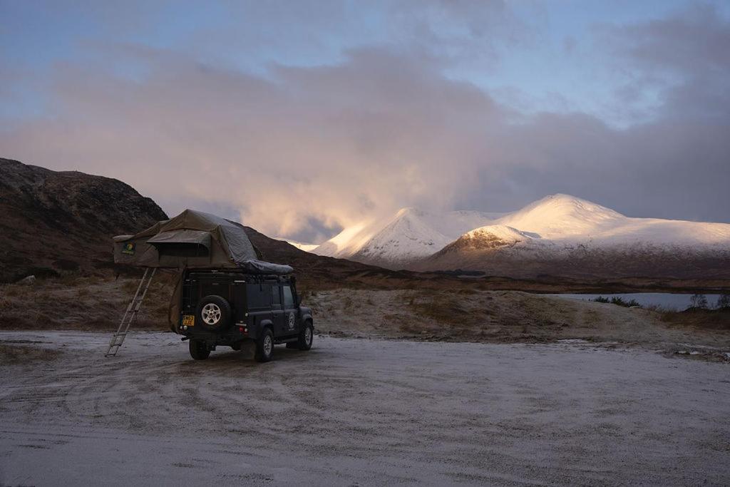 莫珀斯Land Rover Defender Luxury Camper的山边有遮蔽处的吉普车