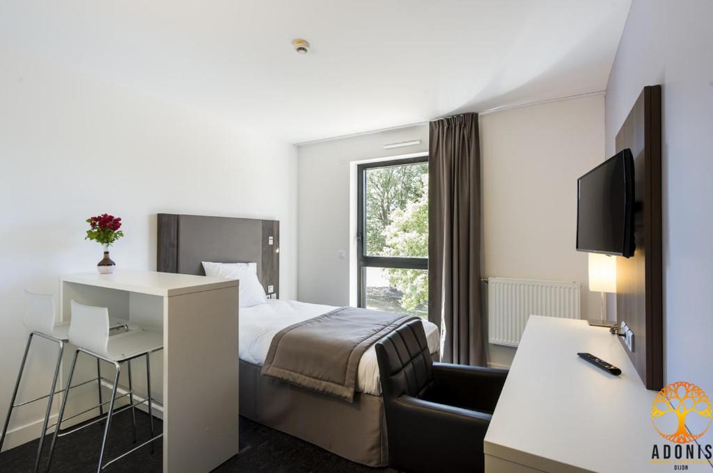 第戎Adonis Dijon Maison Internationale的配有一张床和一张书桌的酒店客房