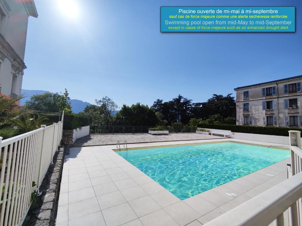 艾克斯莱班Grand studio 38m2 dans ancien palace avec piscine et place de parking privée的一座带白色围栏的游泳池和一座建筑