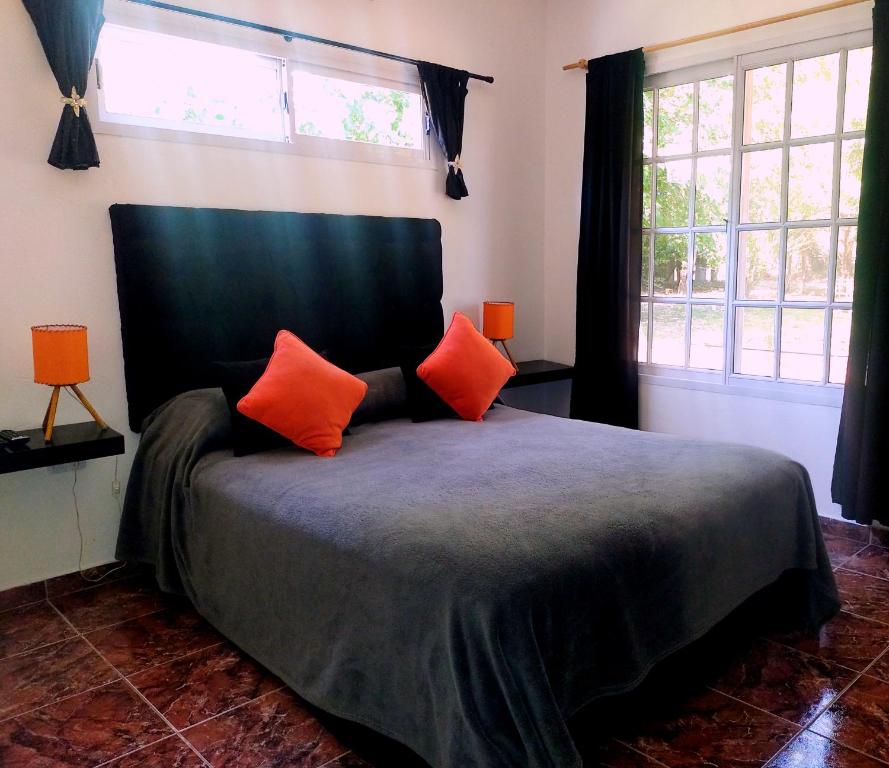 埃塞萨Posada Quinta Pata的一间卧室配有一张带两个橙色枕头的床