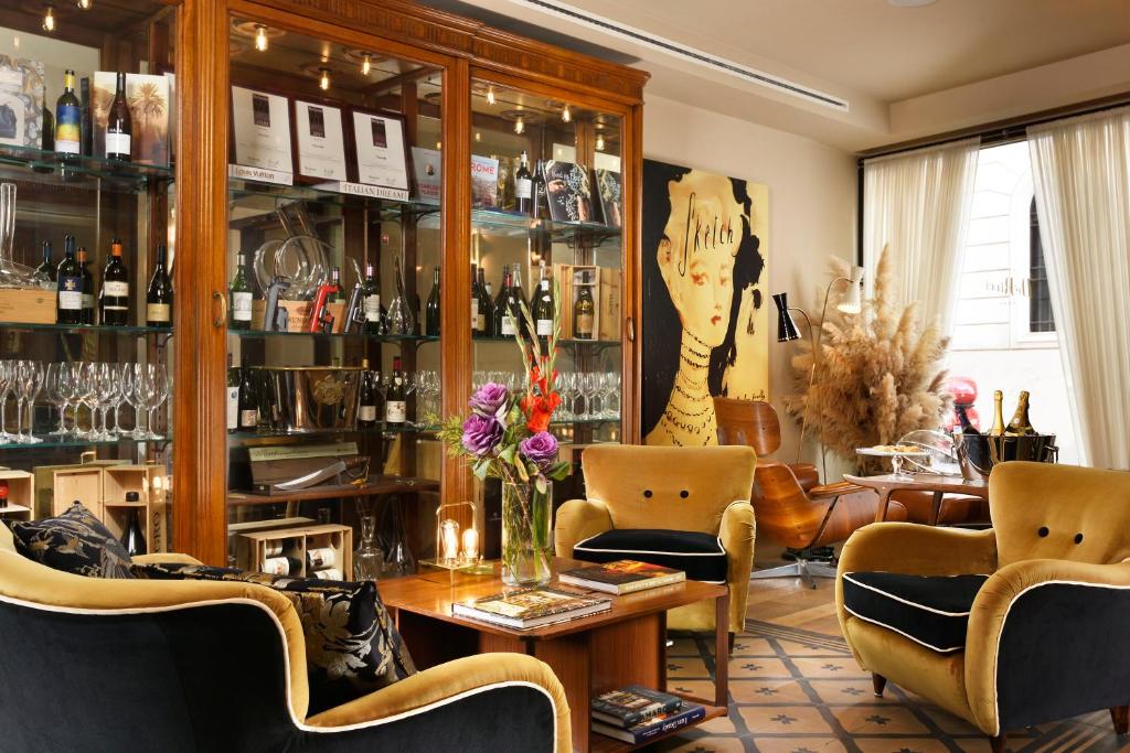 罗马Hotel De' Ricci - Small Luxury Hotels of the World的一间房间,配有椅子和鲜花桌子