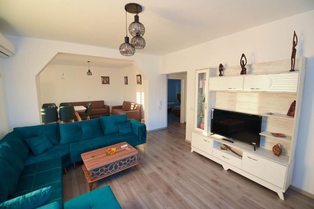 都拉斯Vila Emma的客厅配有蓝色的沙发和电视