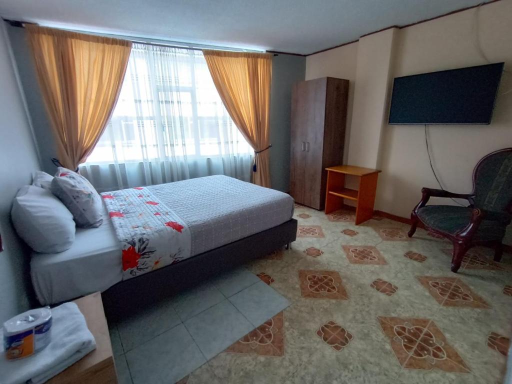帕斯托HOTEL DINO的卧室配有床、椅子和窗户。