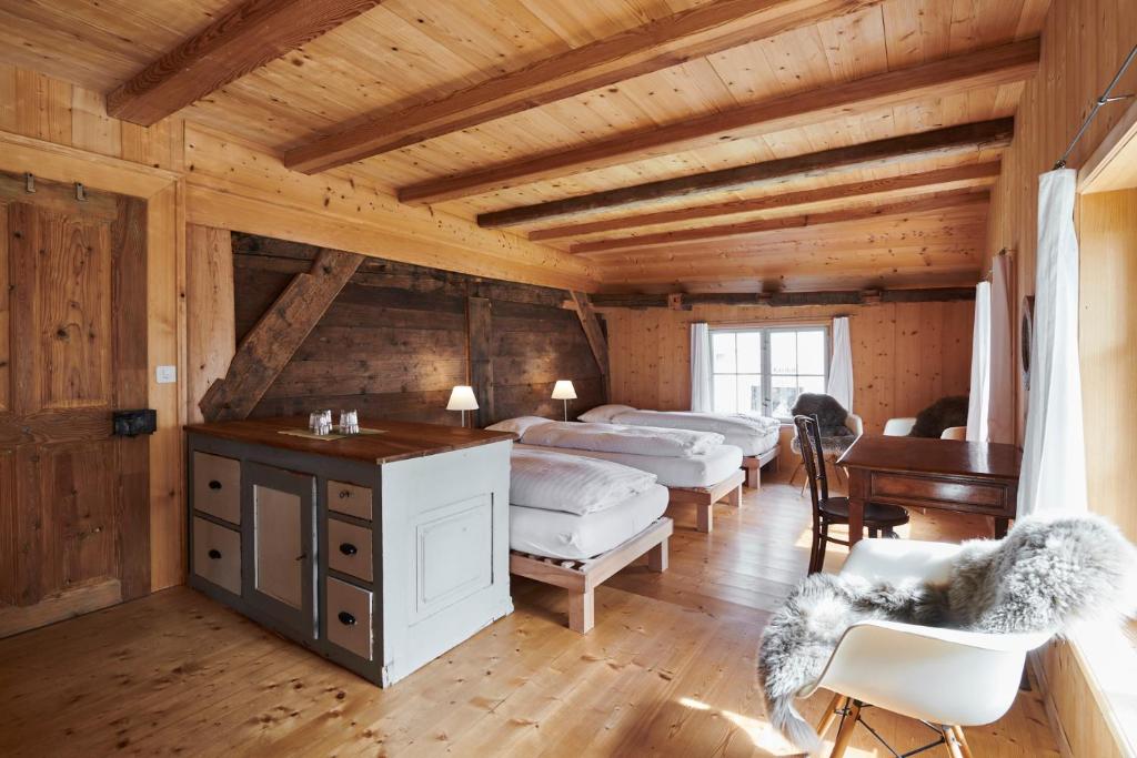 罗曼斯霍恩Fischerhäuser Romanshorn的一间卧室配有四张床,客房内配有一张书桌